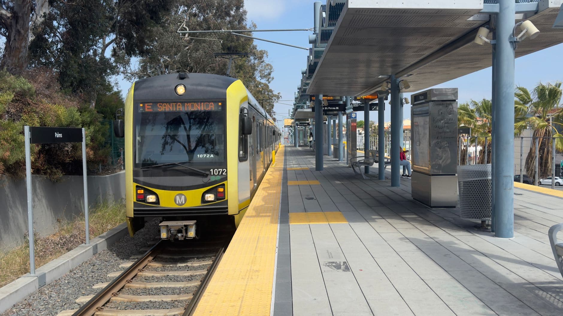 Metro train arriving at Palms station heading to Santa Monica. Urban transit scene.